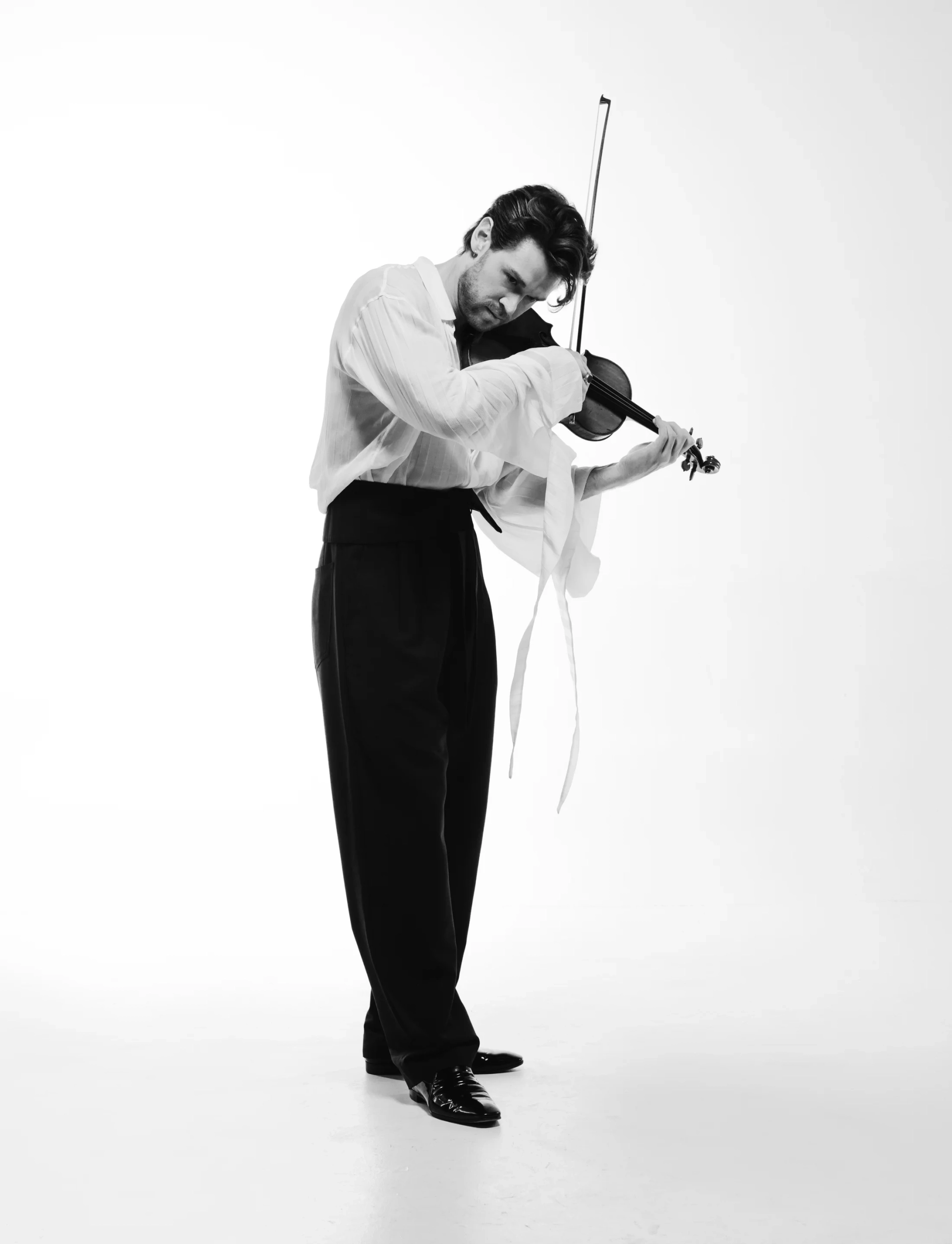 Blake Pouliot performing with dramatic motion in black and white